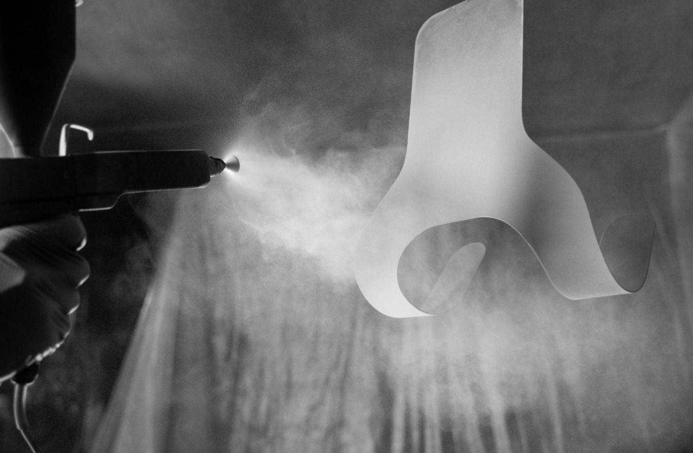 Oberflächenbeschichtung • © www.freepik.com Eine Person sprüht Farbe auf ein hängendes Objekt.